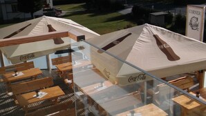Outdoor seating with Coca-Cola branded umbrellas and tables. - Apartmány Belveder (Vysoké Tatry)