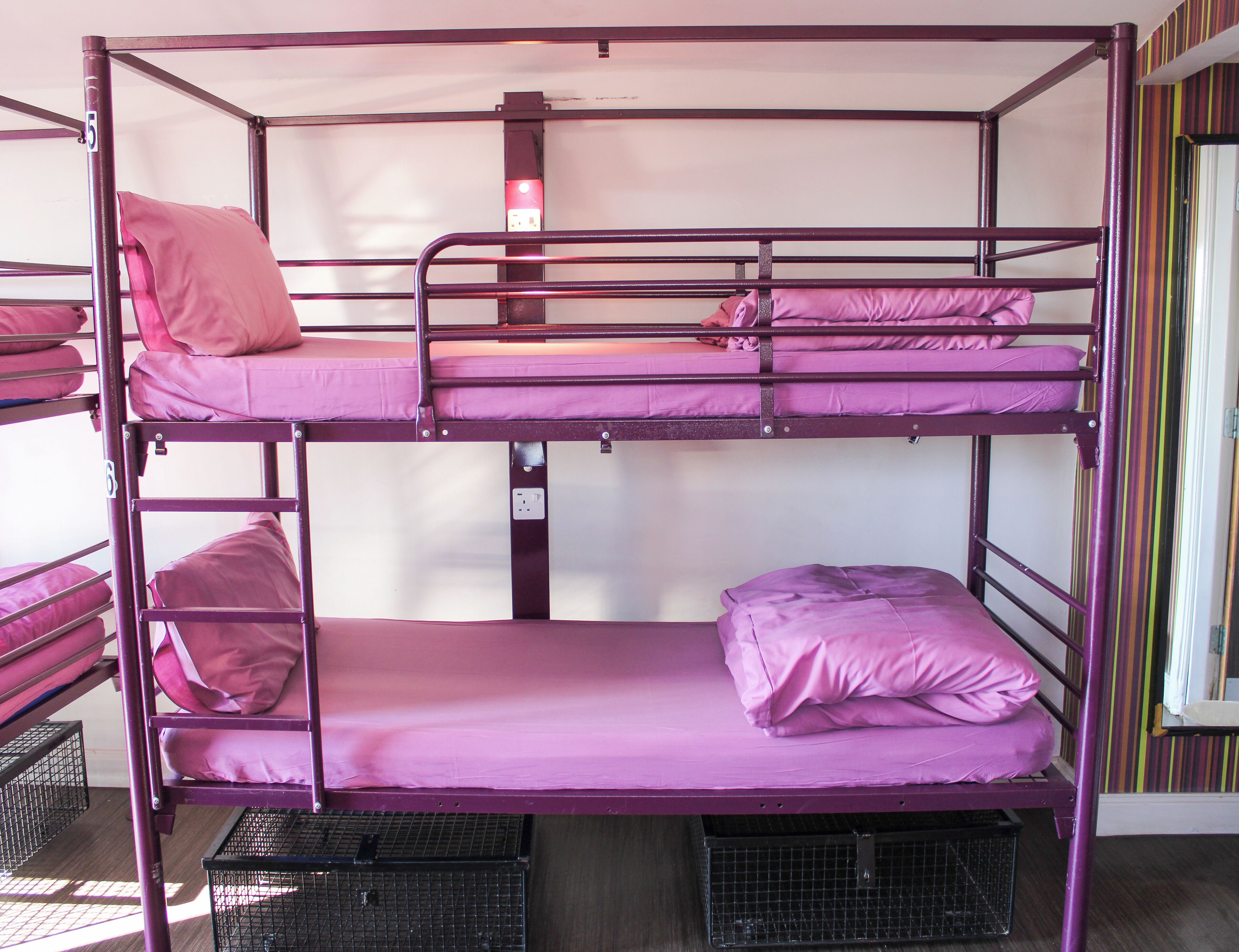 A bunk bed with two levels, each with a mattress and pillows.
