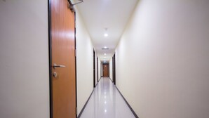 A long, narrow hallway with a wooden door on the left and a white wall on the right. - 118 Hotel Macalister (George Town)