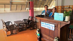 A reception area with a wooden counter, chairs, and a tiled floor. - Baan Talay (Pattaya)