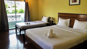 A hotel room with two beds, a wooden headboard, a nightstand with a lamp, and a window with curtains. - Baan Talay (Pattaya)