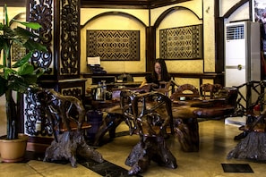 A restaurant with wooden furniture and decorative wall panels.