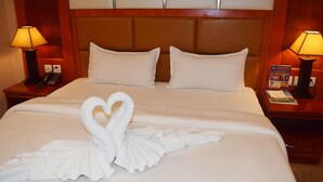 A hotel room with a large bed, two nightstands, a telephone, and two lamps. - Dansavanh Vientiane Hotel (Vientiane)