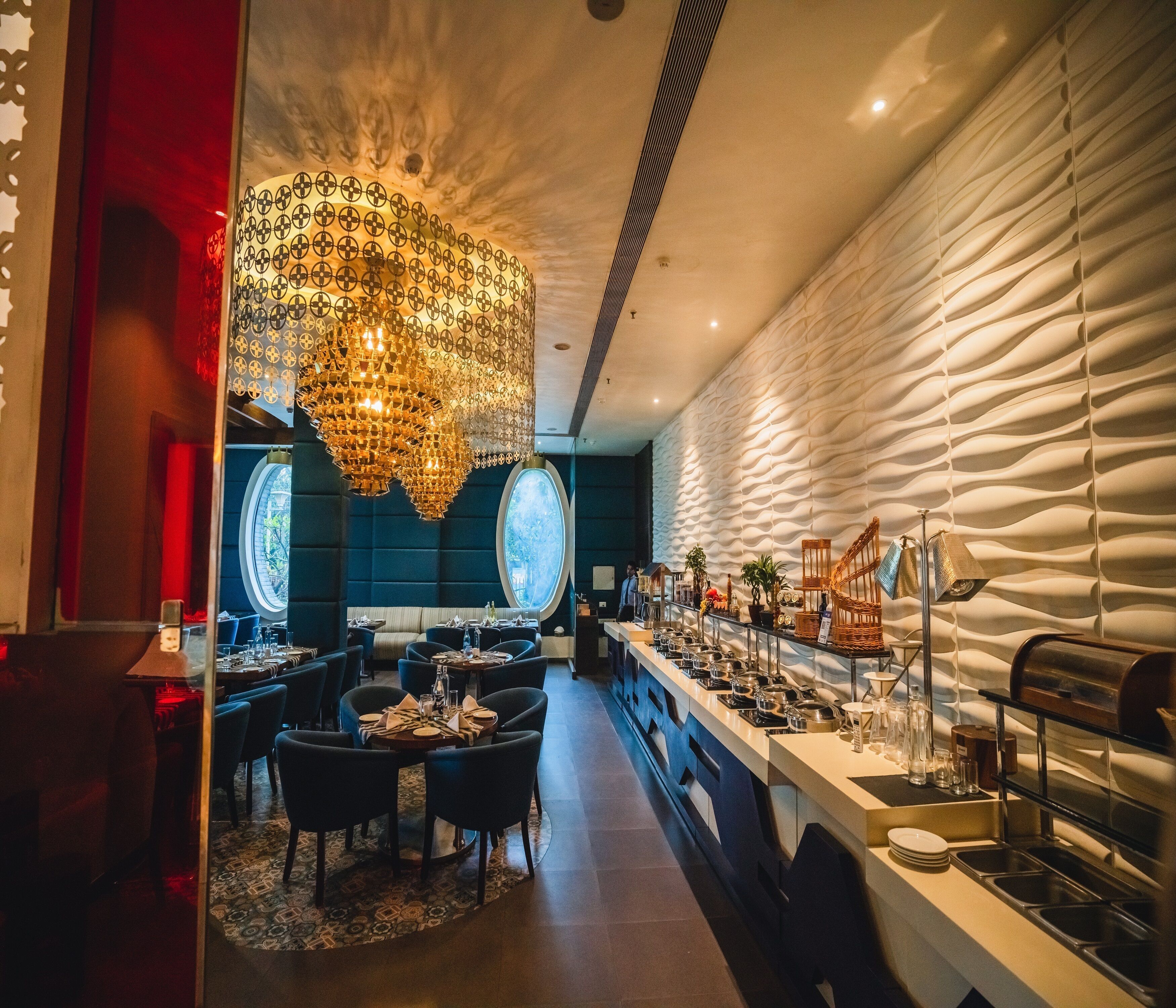 Een modern restaurant met een centrale eetruimte, een bar en een buffet.