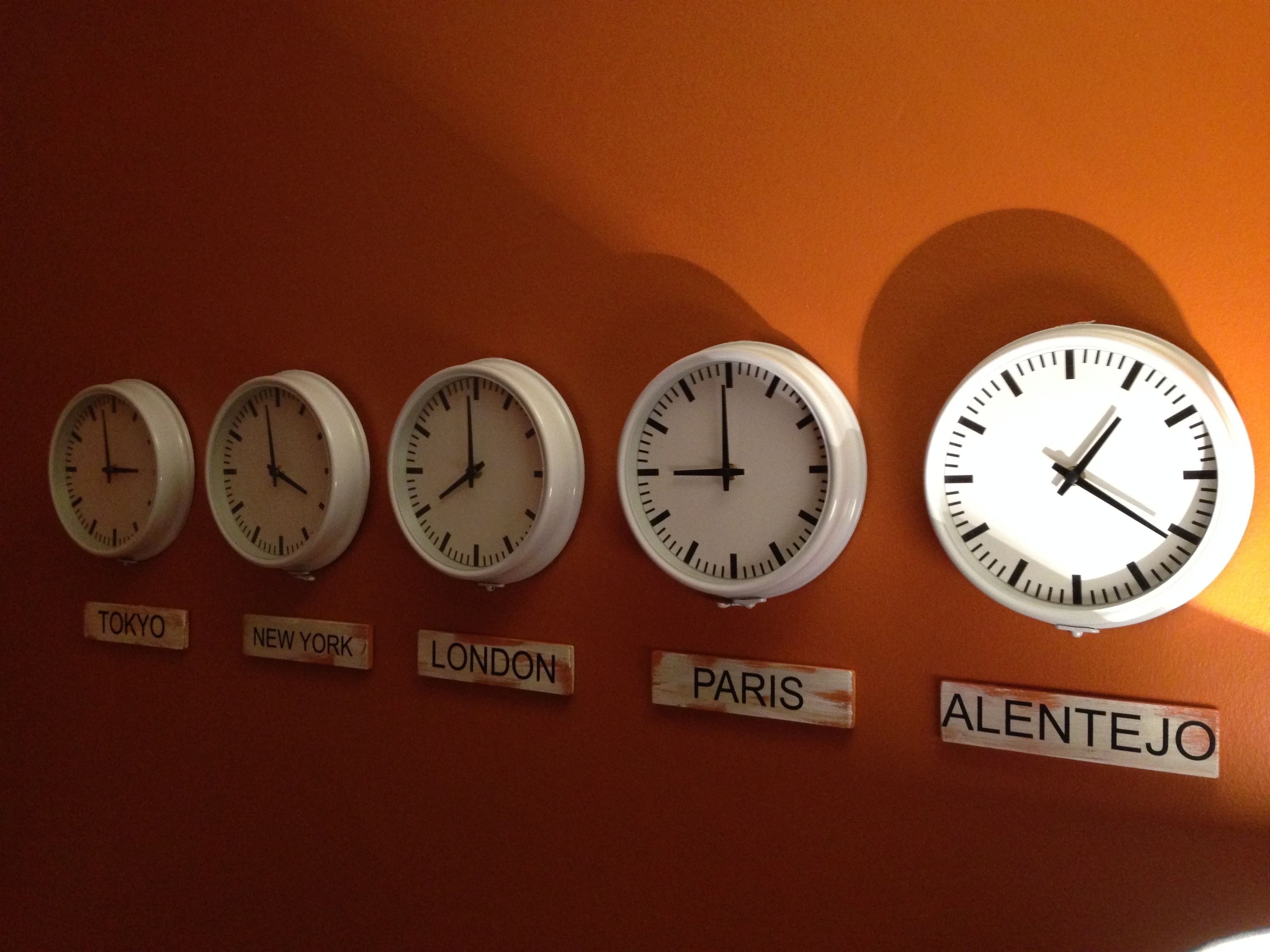 Cinq horloges sont accrochées au mur, et chacune indique l’heure d’une ville différente : Tokyo, New York, Londres, Paris et l’Alentejo.