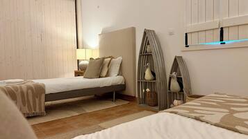 A bedroom with a bed, bedside table, lamp, and decorative items.