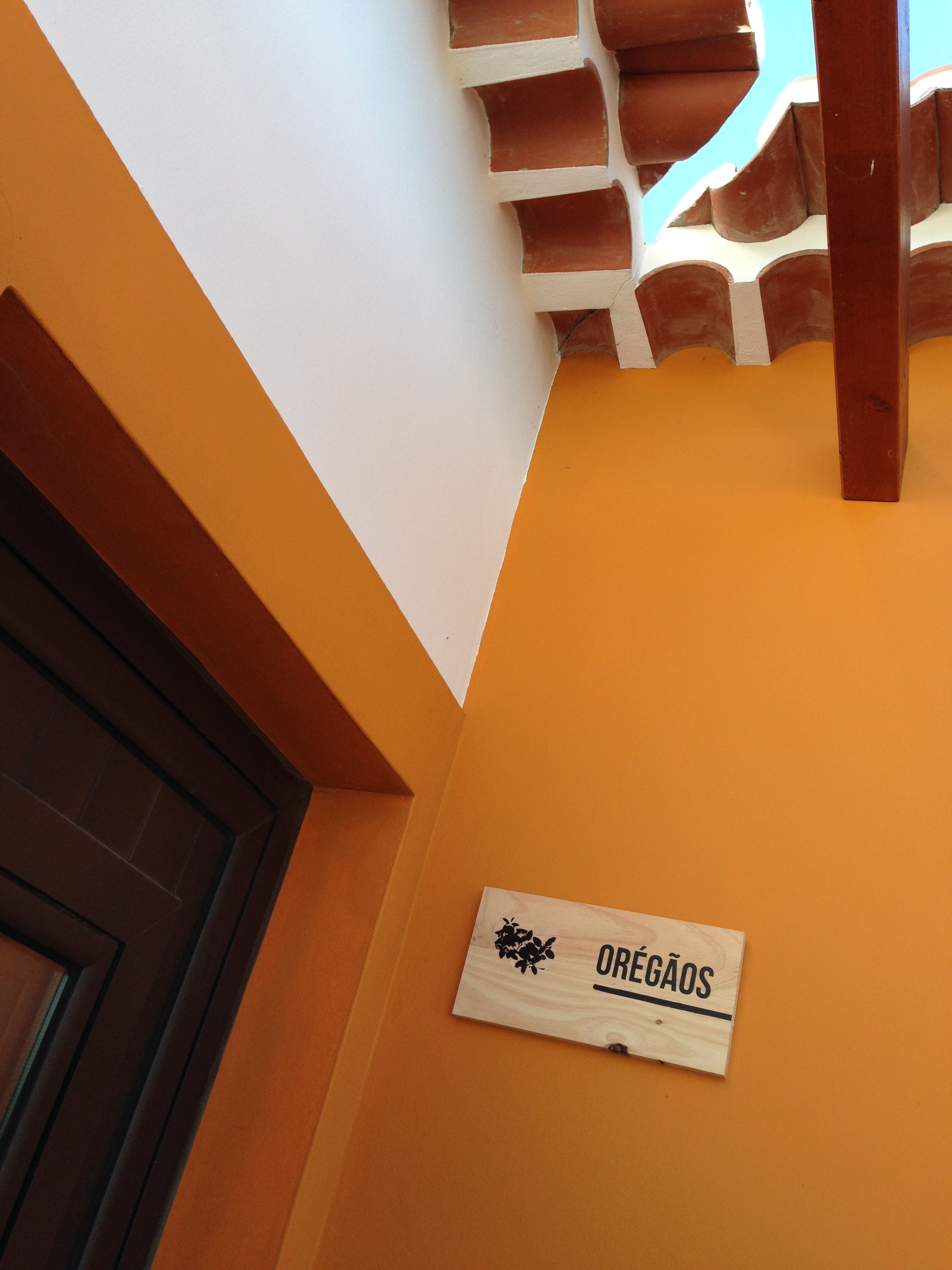 A wooden sign with the text "OREGÃOS" on a wall.