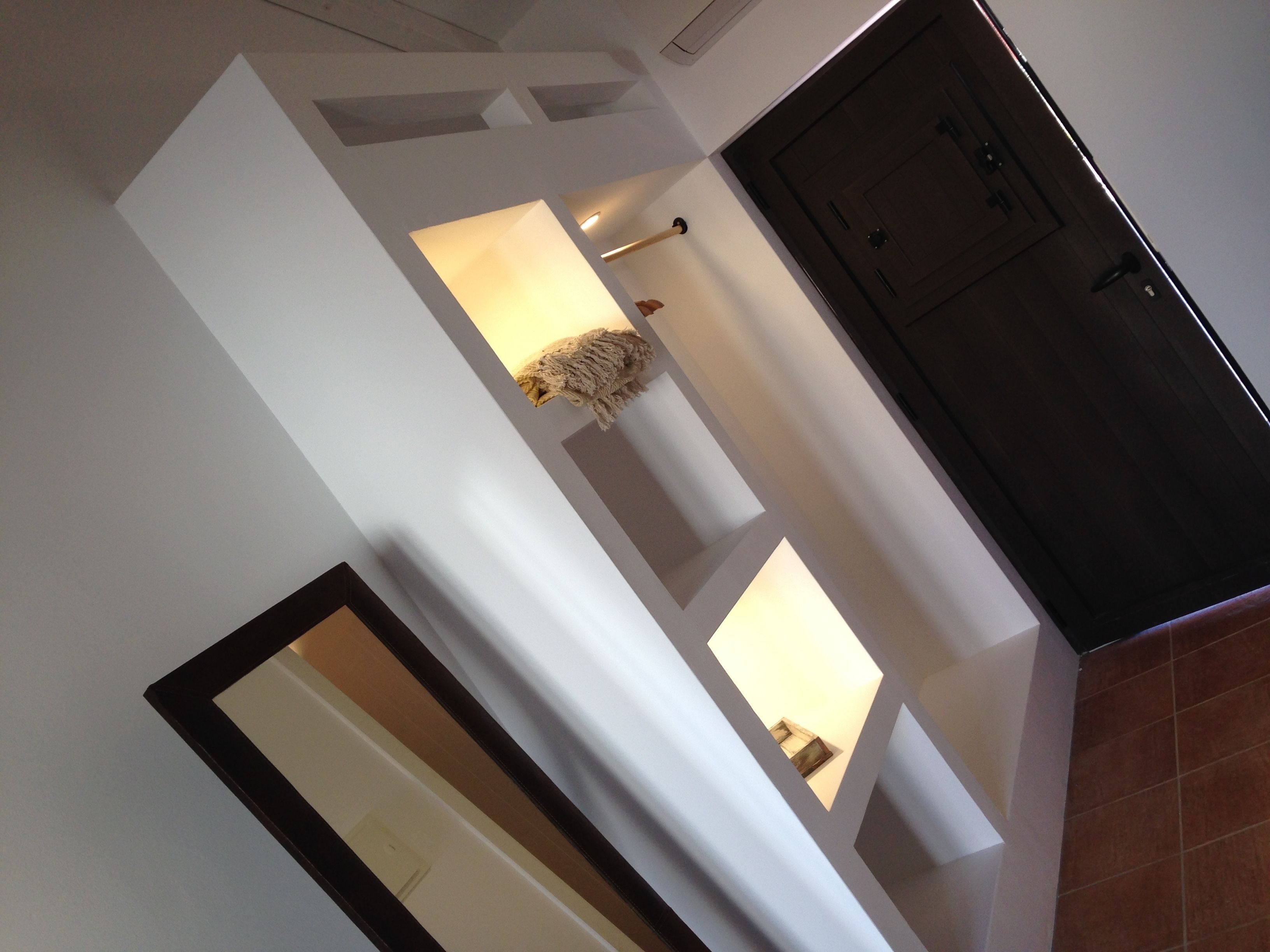 Una habitación con un espejo grande, una puerta y una lámpara.