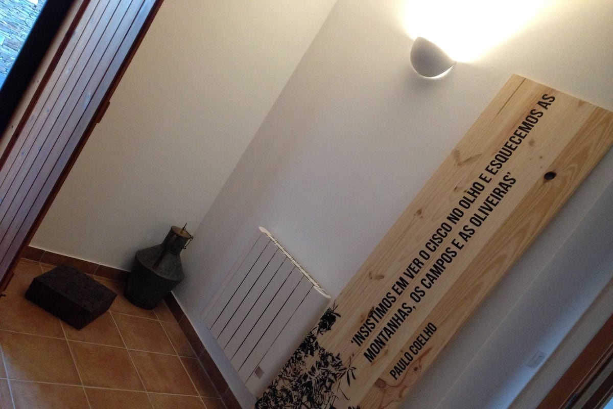 A hallway with a wooden sign, a radiator, and a floor lamp.