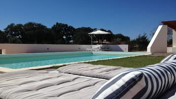 Alberca al aire libre y camastros