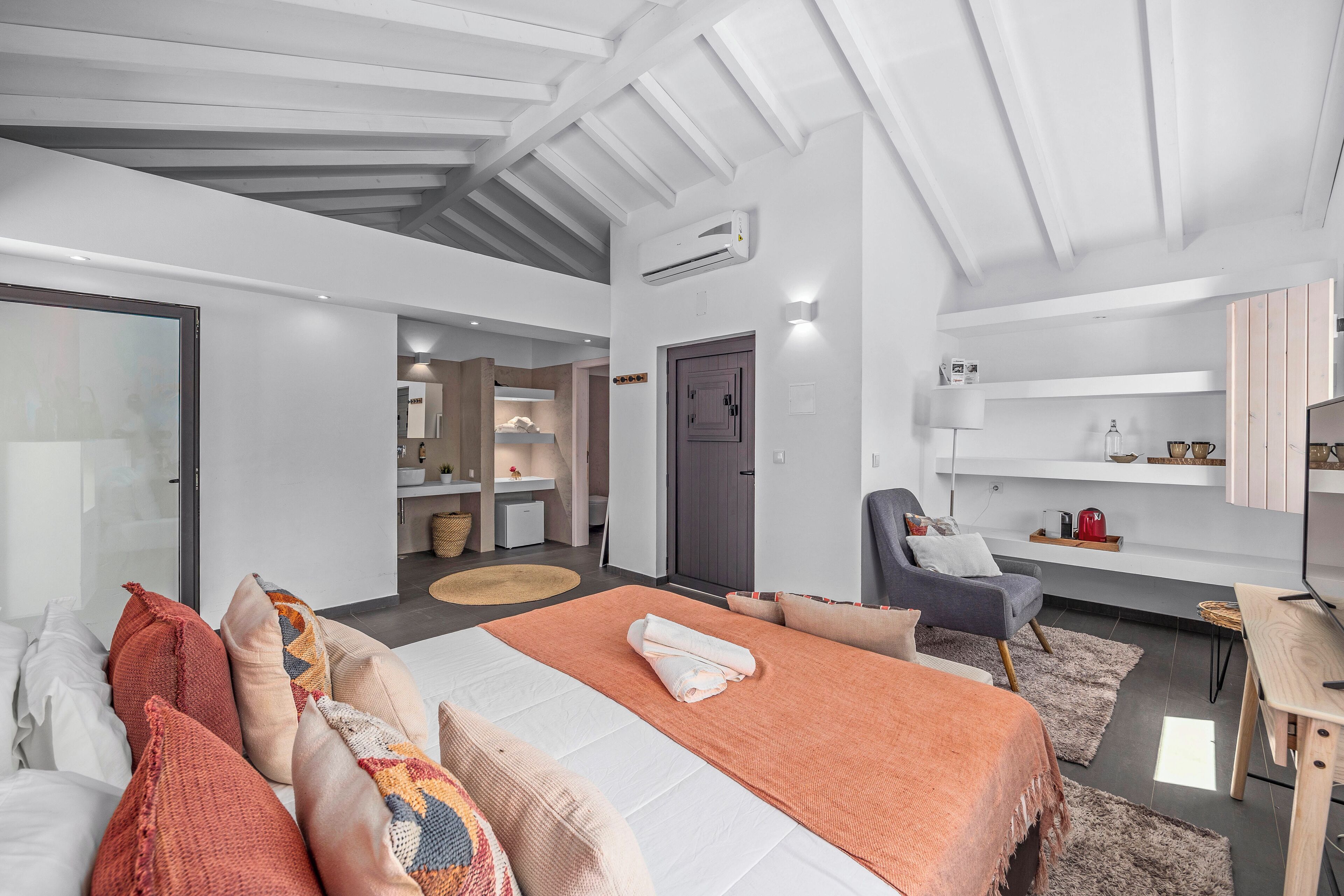 Een moderne hotelkamer met een groot bed, een bureau en een zithoek.