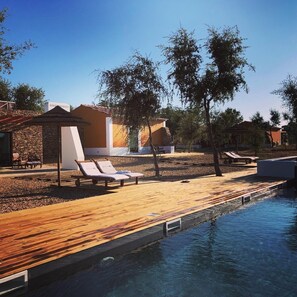 A pool area with lounge chairs and a wooden deck. - Tons da Terra (Santiago do Cacém)