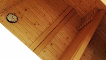Techo de madera con un reloj montado en la pared y estructura de vigas de madera.