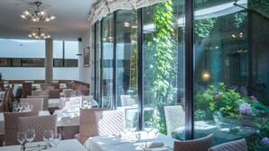 A restaurant with tables set for dining, large windows, and a view of greenery. - Hotel Delle Terme Santa Agnese (Bagno di Romagna)