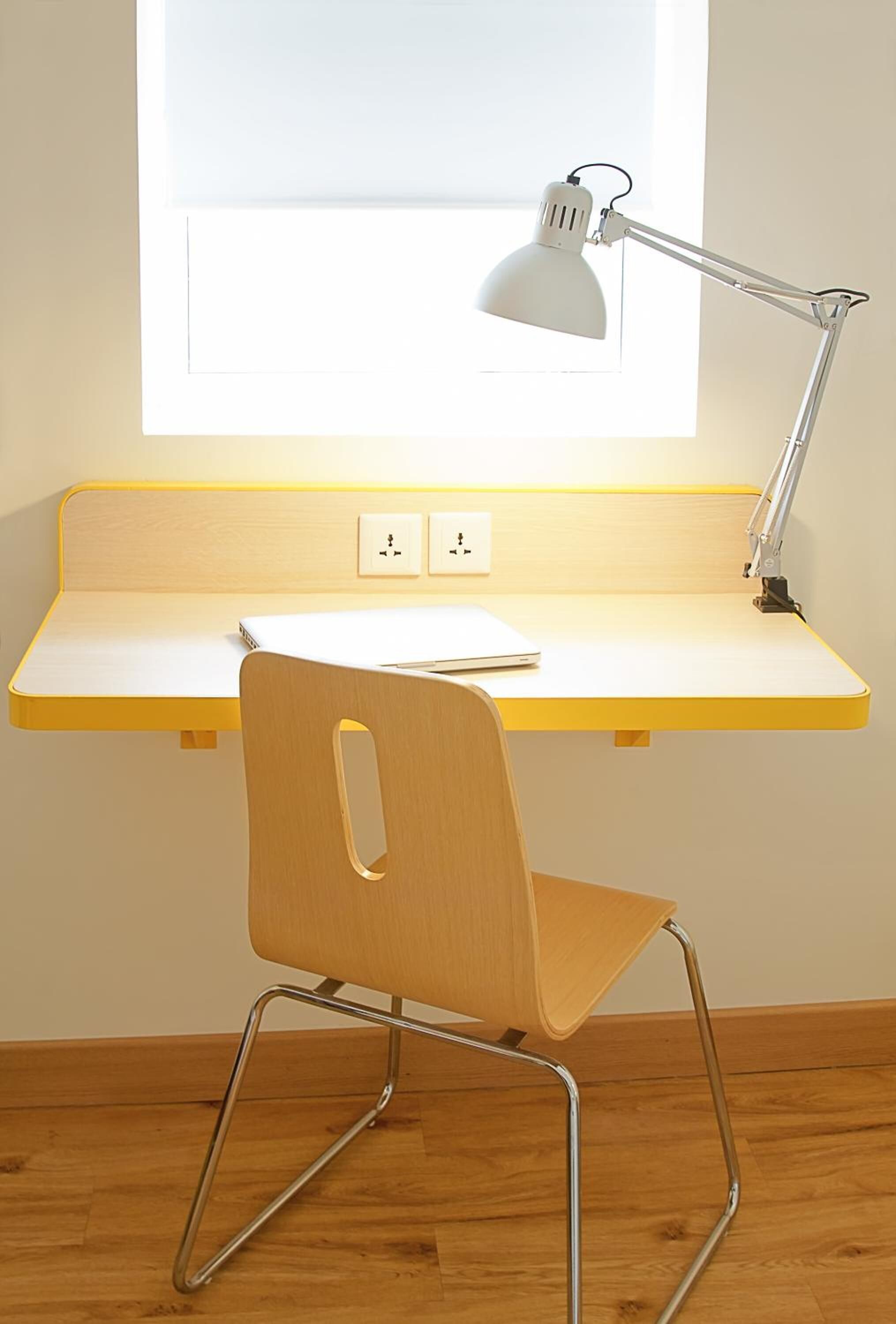 A study area with a desk, chair, and desk lamp.
