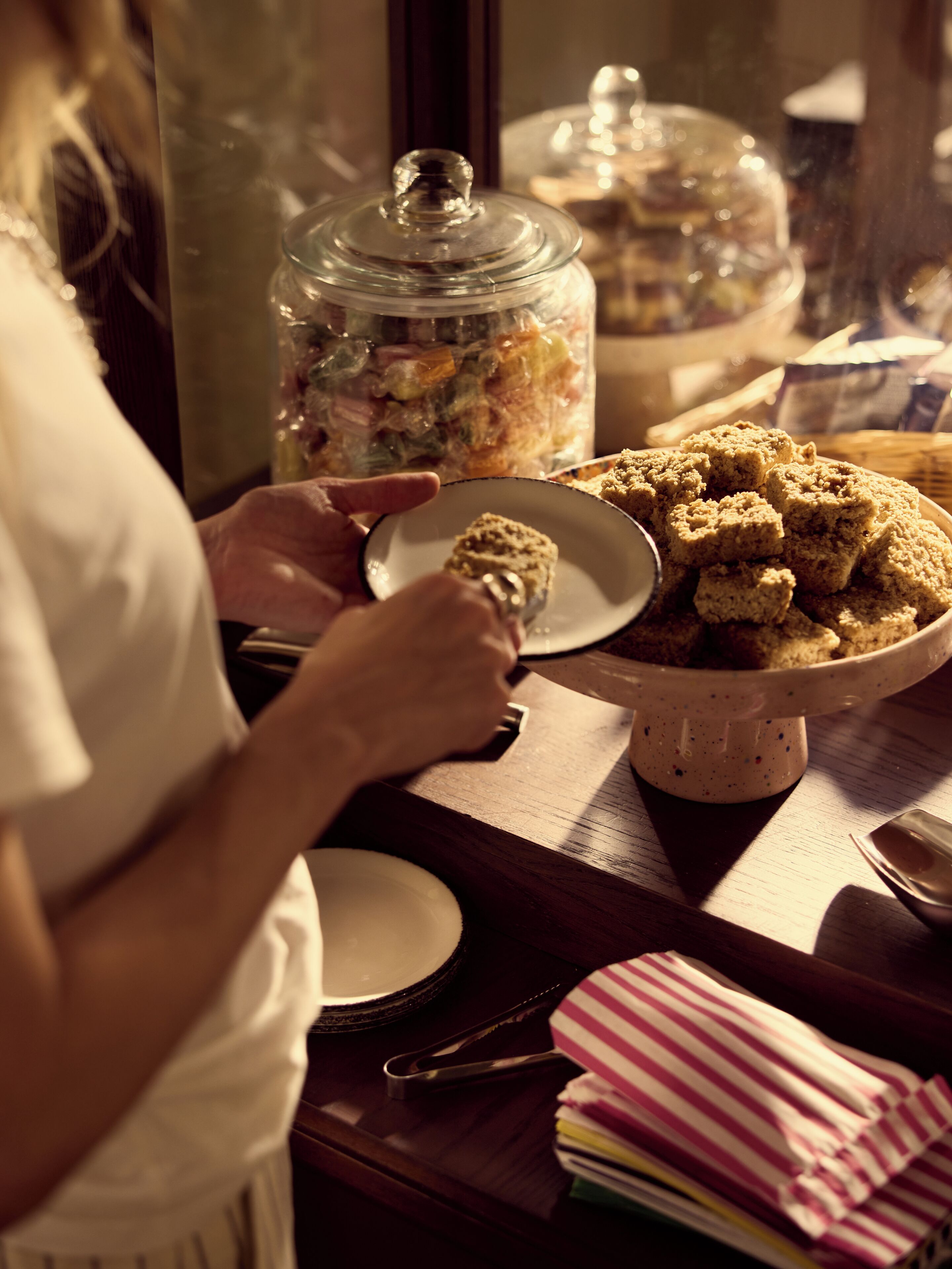 A person serving food from a bowl on a wooden table.
