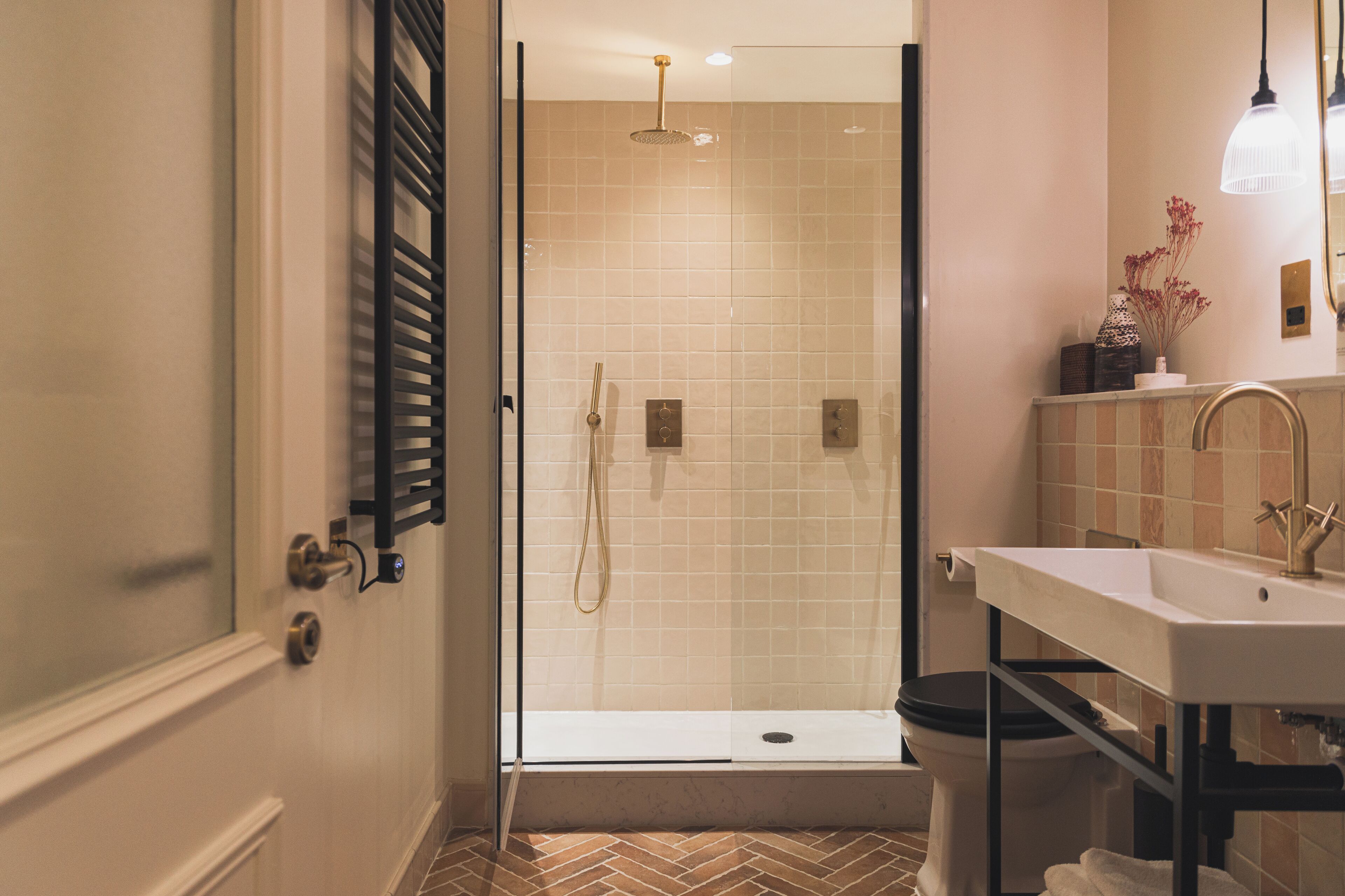 A modern bathroom with a glass-enclosed shower, a white sink, and a toilet.