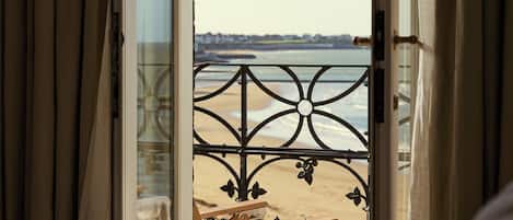 A room with a large window overlooking a beach.