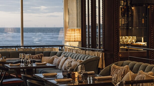 A restaurant with a view of the sea, featuring a bar area with bottles and glasses, and a seating area with tables and chairs. - No.42 by GuestHouse Margate (Margate)