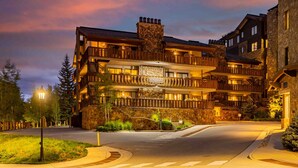 A multi-story hotel with balconies, stone facade, and a sign reading 'ENZIAN.' - Enzian - CoralTree Residence Collection (Vail)