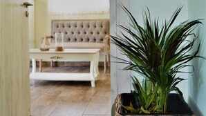 Une pièce comprenant un panier en osier contenant une plante, un canapé à motifs et une table avec une bougie.