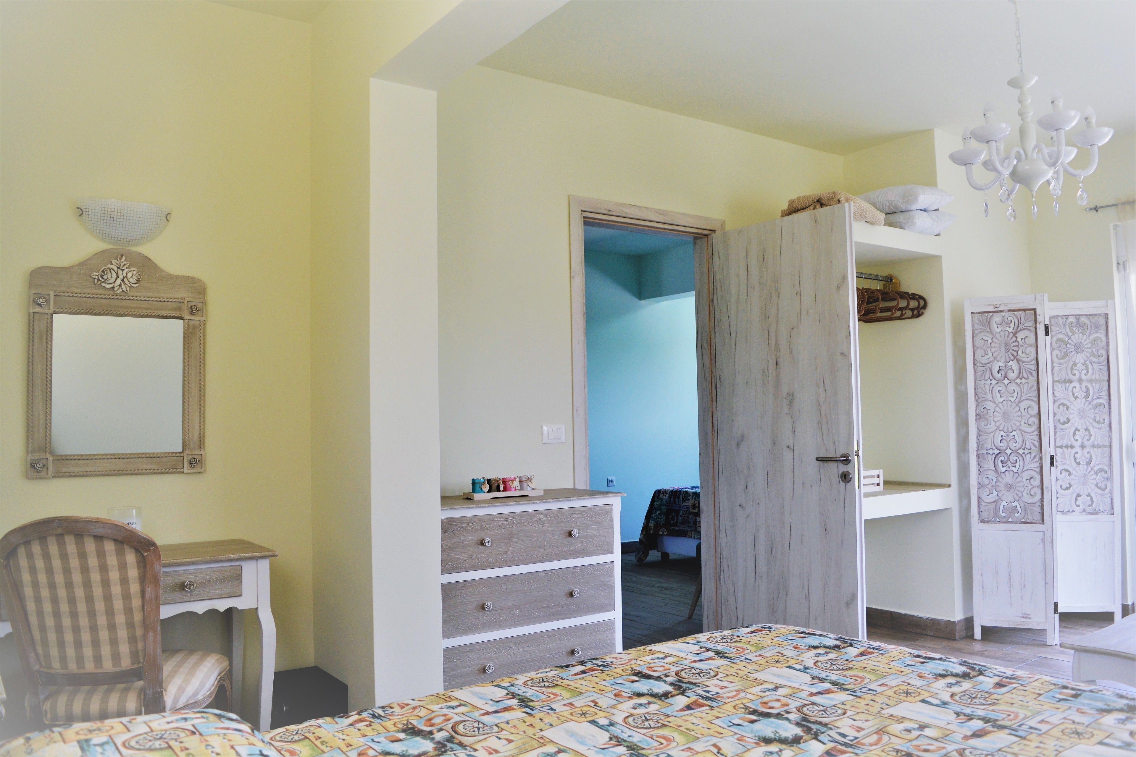 A bedroom with a bed, a desk, a dresser, a chair, and a wardrobe.