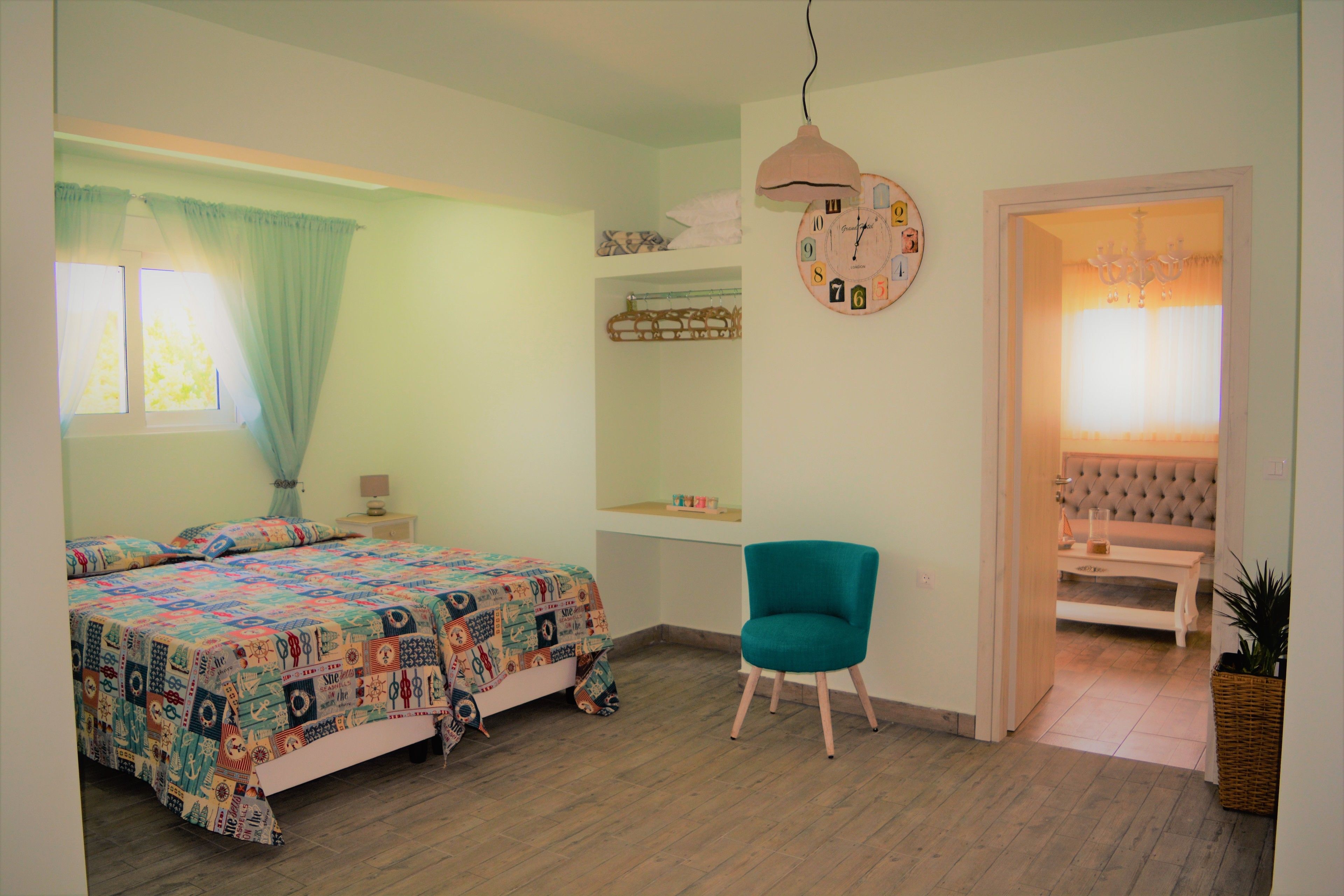 Une chambre à coucher comprenant un lit, une chaise, une horloge et une porte donnant sur une autre pièce.