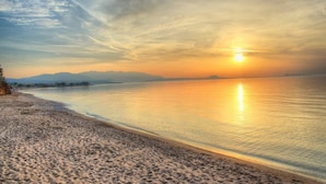 A beach with a calm sea, a clear sky, and distant mountains. - Alkionis Beach Hotel Apartments (Rethymnon)