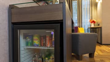 Eine Minibar mit Getränken und ein an der Wand befestigter Fernseher.