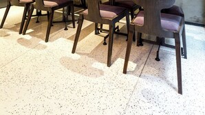 A modern dining area with a long table and chairs, a concrete wall with decorative items, and a framed picture. - Lampa Design Hotel - Special Class (Istanbul)