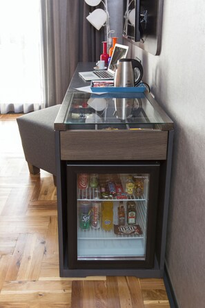 A minibar with various beverages and snacks, a laptop, a kettle, and a cup on a glass table. - Lampa Design Hotel - Special Class (Istanbul)