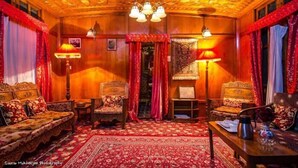 A traditional room with wooden walls, a patterned carpet, and classic furniture. - Lily of Nageen (Srinagar)