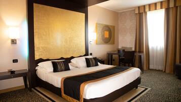 A hotel room with a large bed, a desk, and a chair.