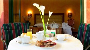 A breakfast table set with croissants, a vase of white flowers, and a glass of orange juice. - Hotel Motel Del Duca (Cava Manara)