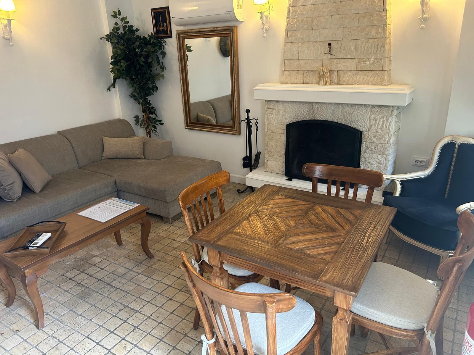 Un salon avec une cheminée, un canapé, une table à manger avec des chaises et une table basse.
