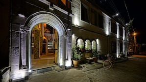 Un edificio storico con un ingresso ad arco, piante in vaso e una bicicletta.