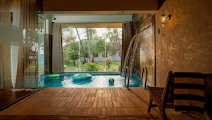 Zona de piscina con vista a palmeras y cielo despejado.