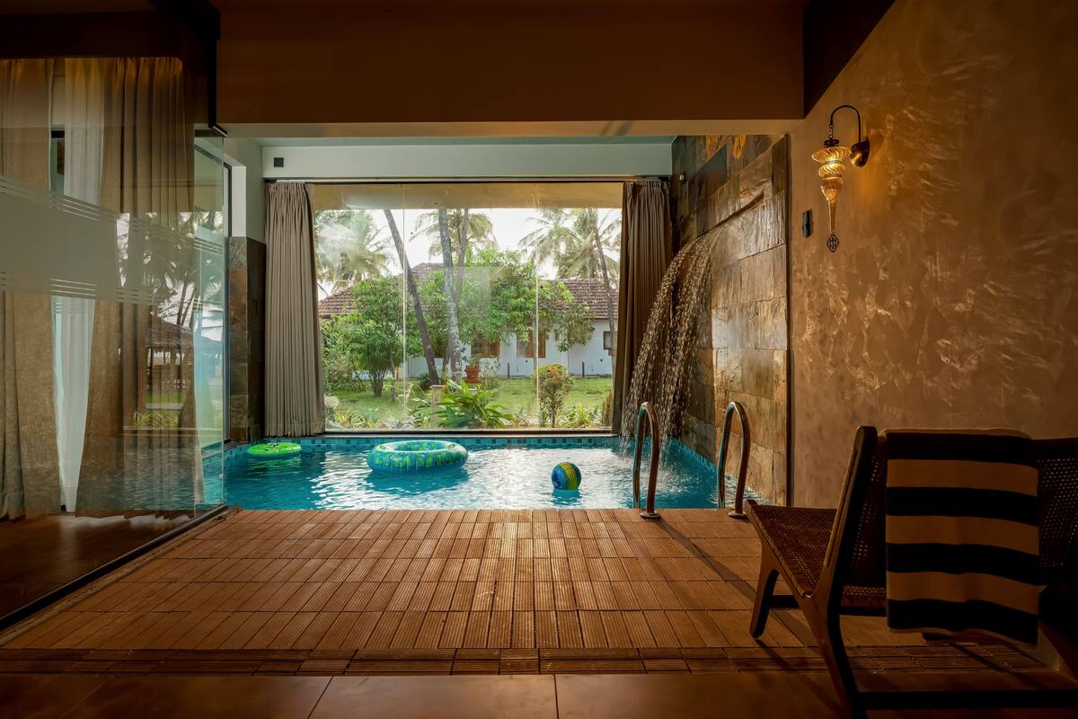 A pool area with a view of palm trees and a clear sky.
