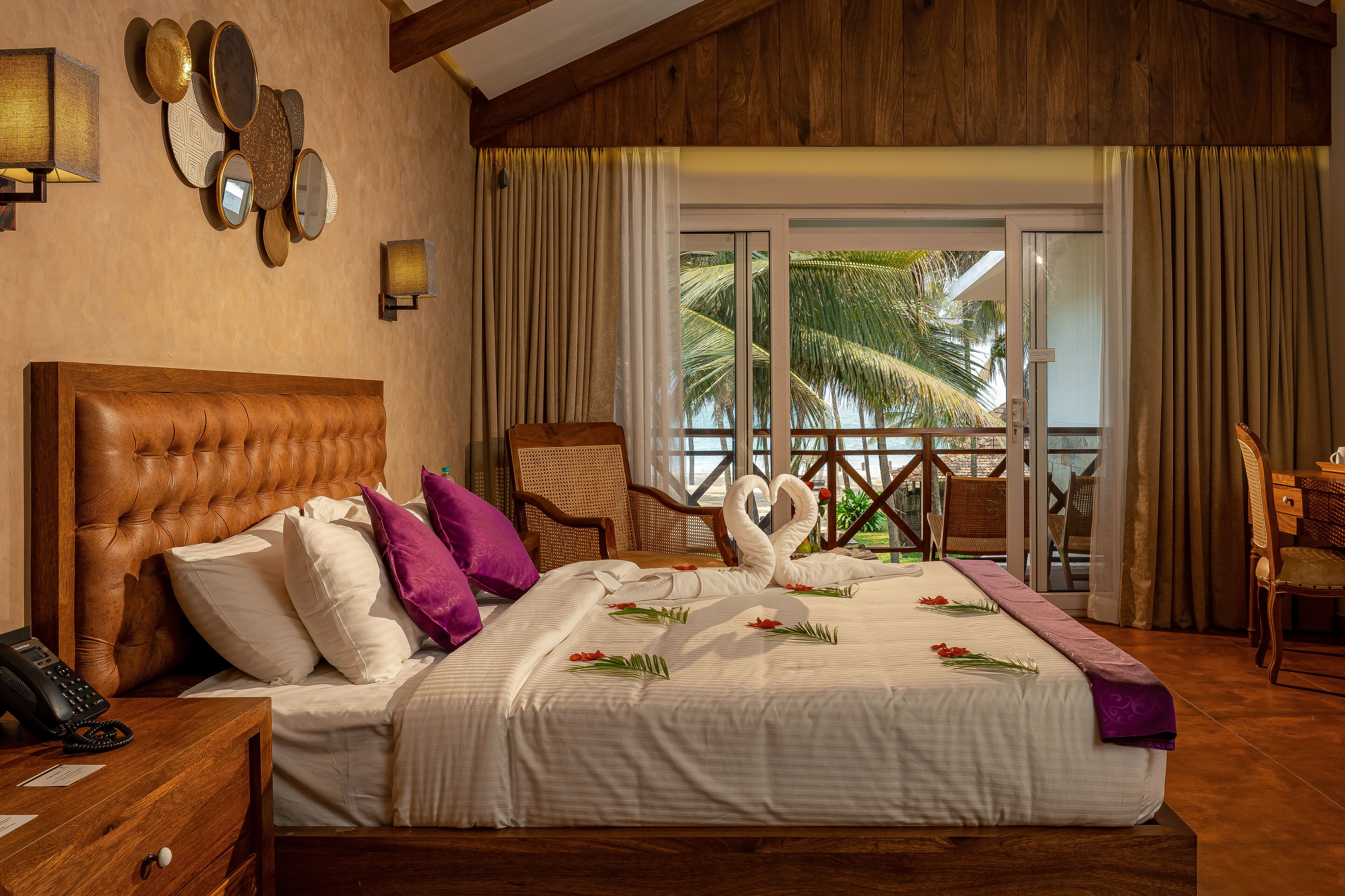 A hotel room with a large bed, a wooden headboard, a telephone, and a nightstand.