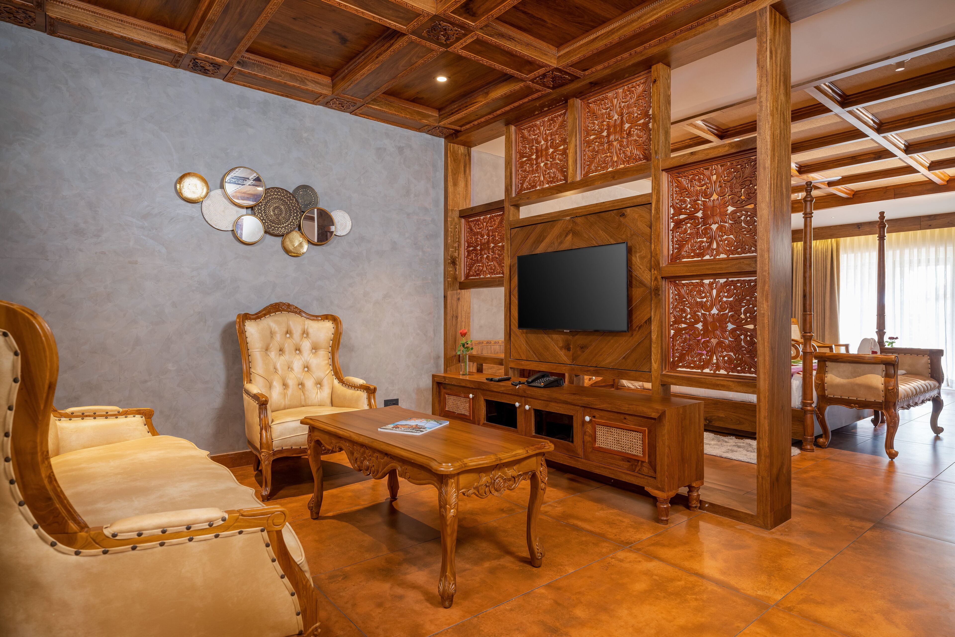 A living room with a wooden TV stand, a large flat-screen TV, a tufted armchair, and a matching sofa.