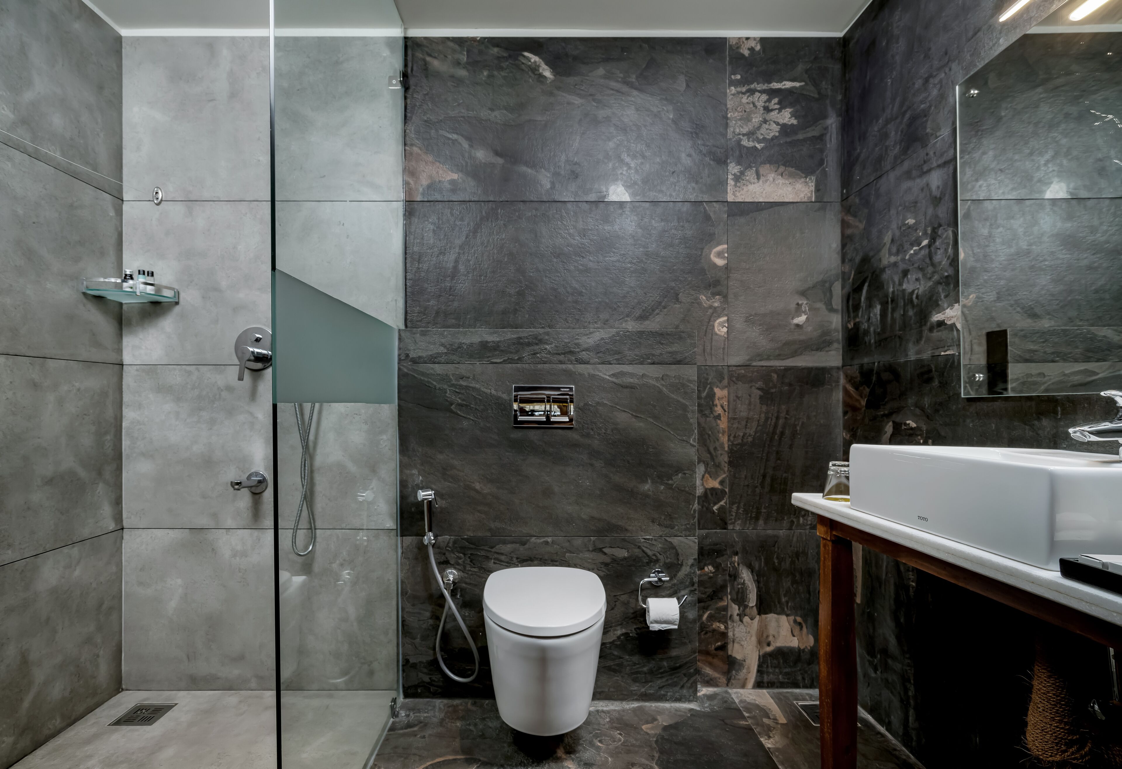 A modern bathroom with a shower, toilet, and sink.