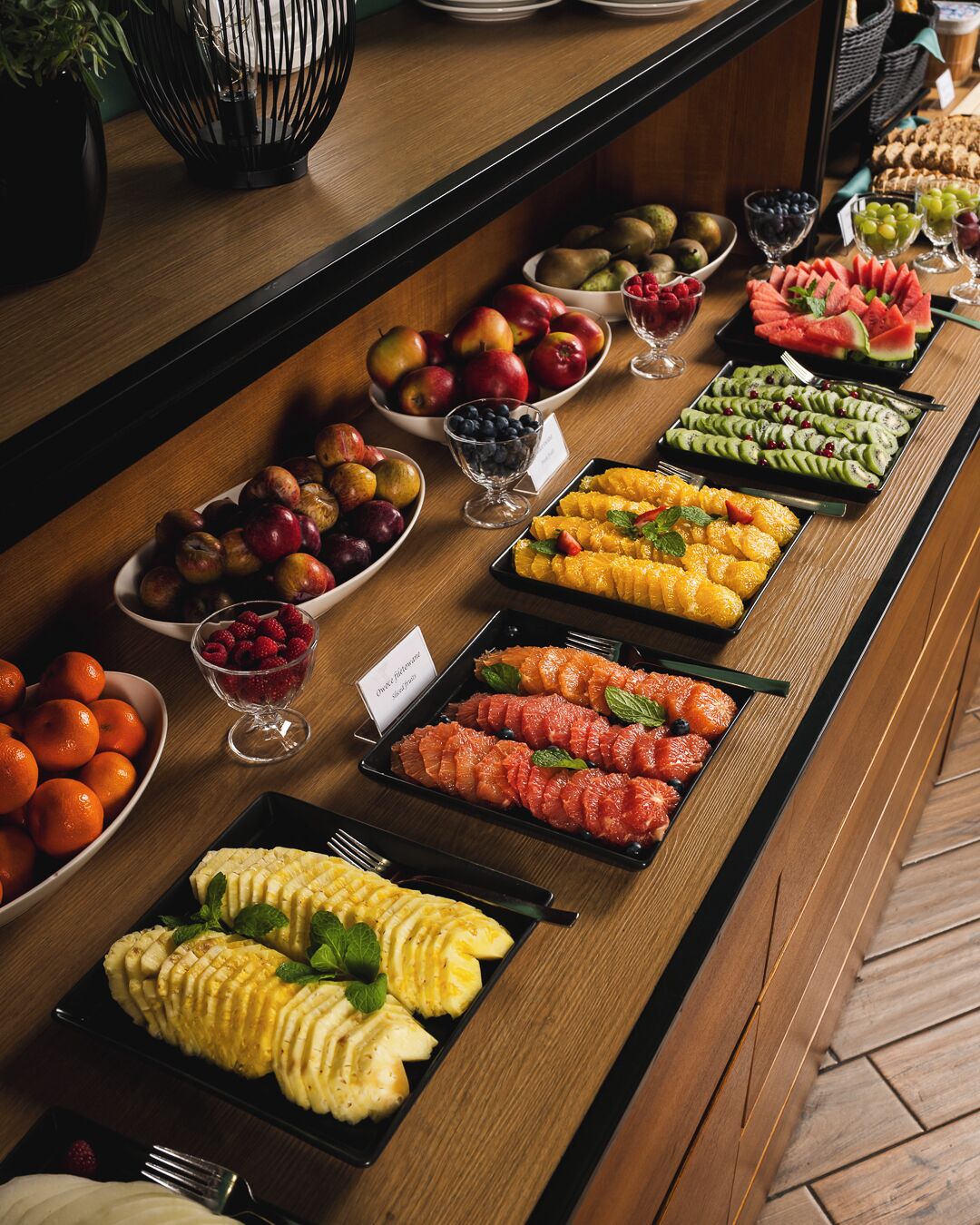 Un bufé con frutas y postres variados.
