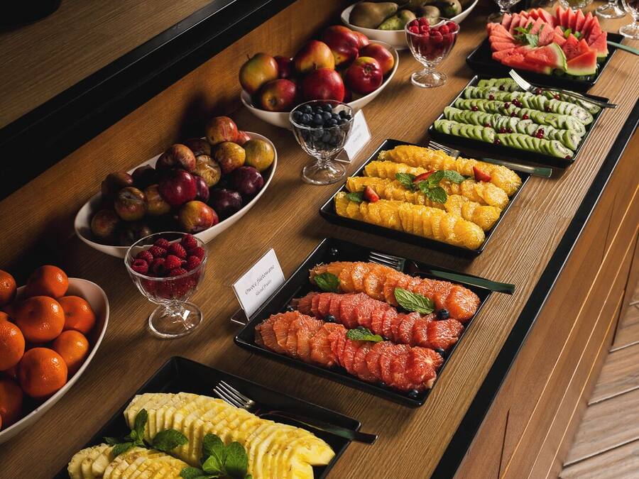 Un bufé con frutas y postres variados.