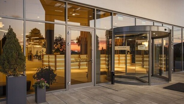 A modern hotel entrance with a revolving door, glass doors, and a reception area visible through the glass. - Focus Hotel Premium Lublin Conference & SPA (gmina Jastków)