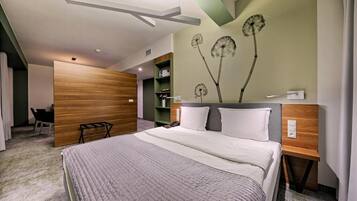 Habitación de hotel moderna con una cama grande, cabecero de madera y una pared decorada con motivos de diente de león.