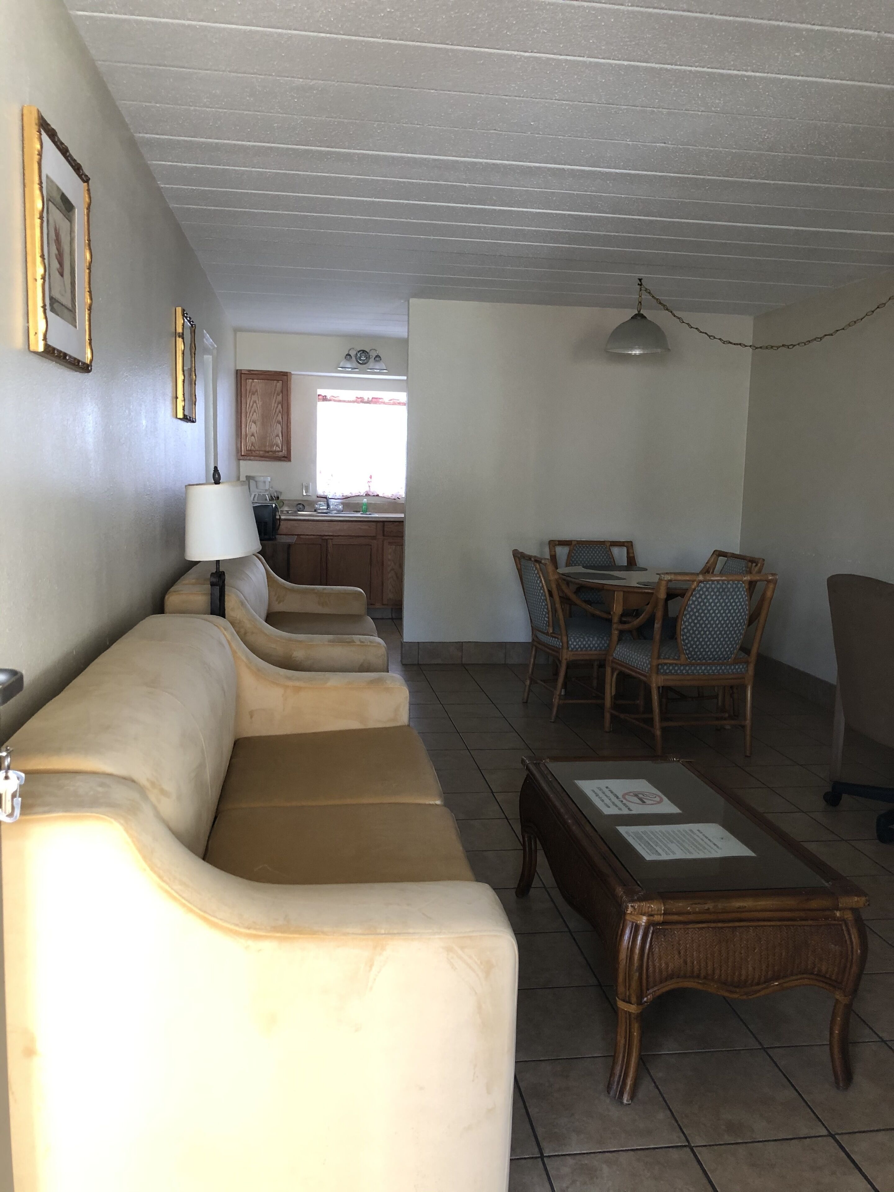 A living room with a sofa, a coffee table, and a dining area with chairs.