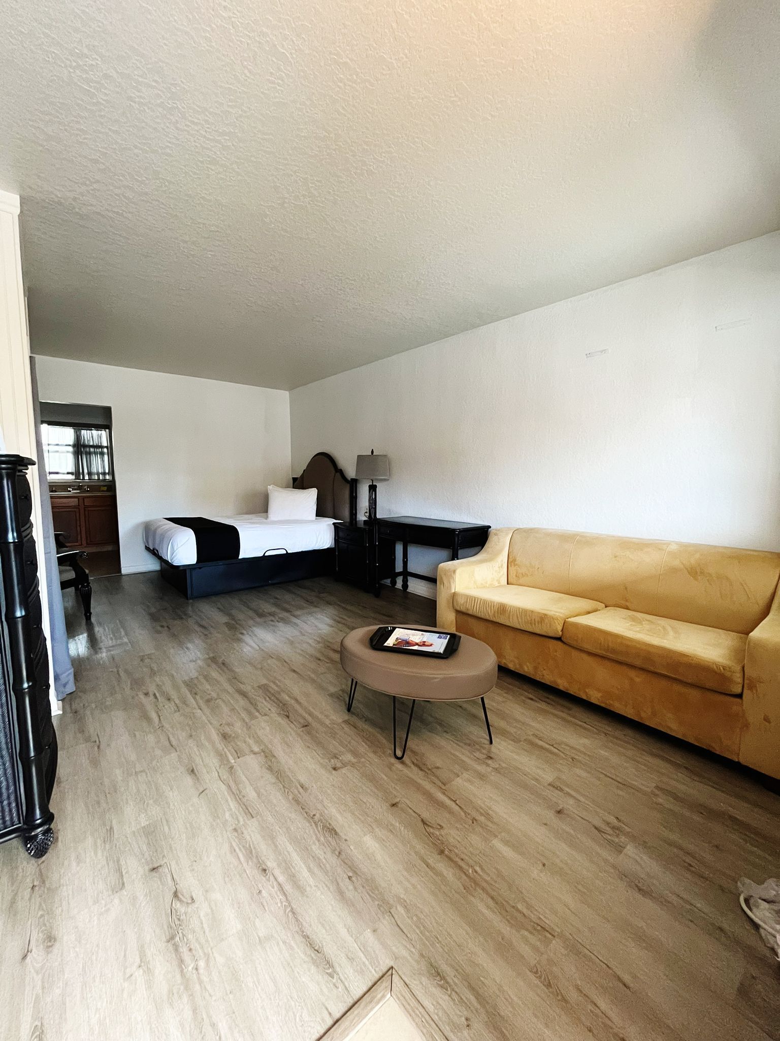 Een moderne woonkamer met een bed, een bank, een salontafel en een bureau.