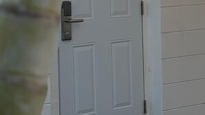 A white door with the number 49, a doorbell, and a metal handle. - Holiday Isles Resort (Madeira Beach)