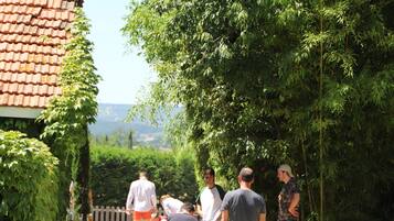 A group of people playing croquet in a garden with a house in the background.