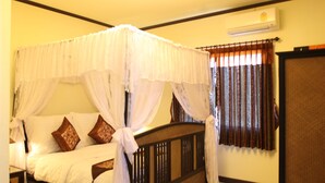 Une chambre à coucher avec un lit à baldaquin, un dais et une tête de lit en bois.